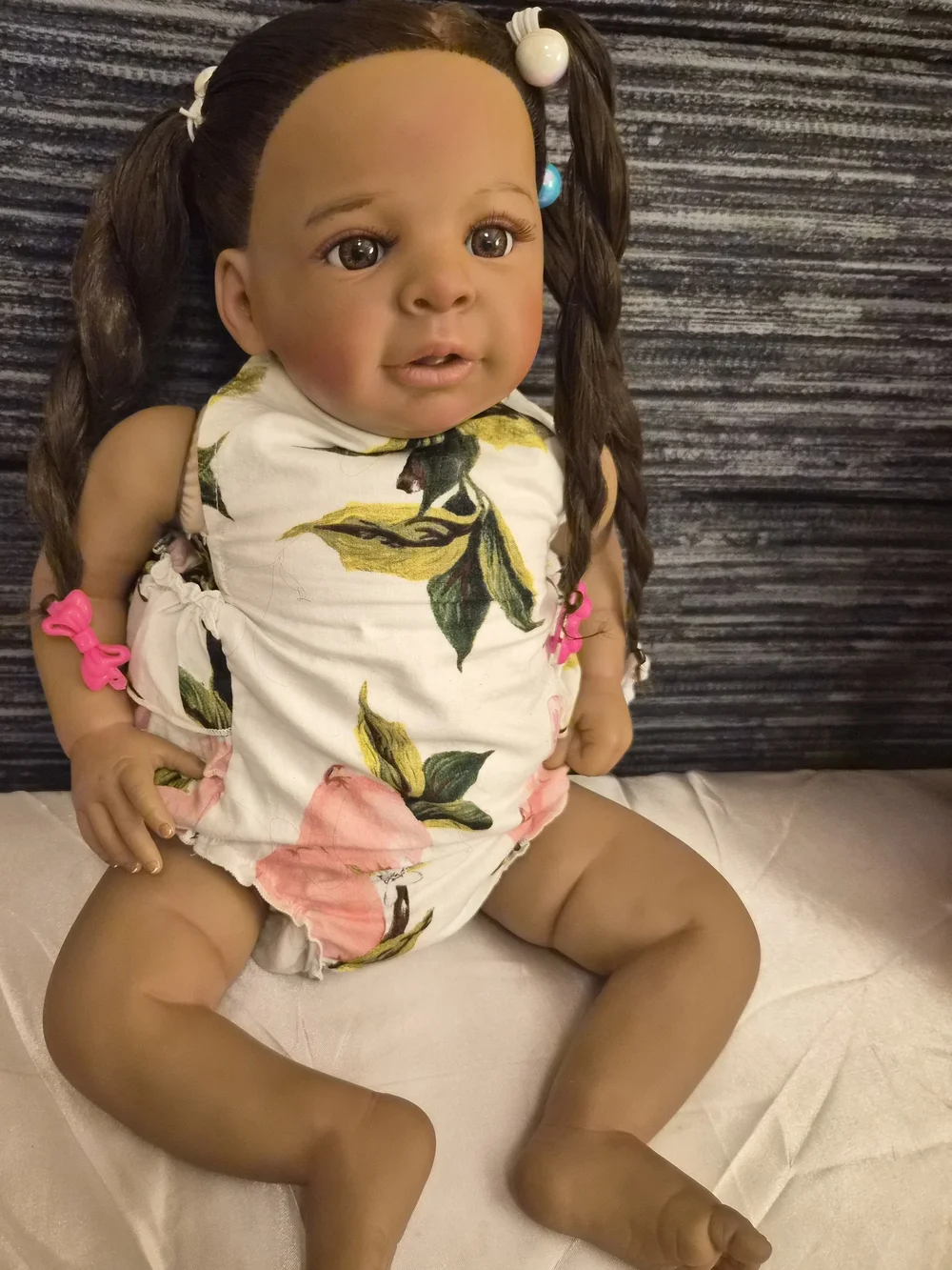 Reborn brown baby doll with pink and white floral outfit